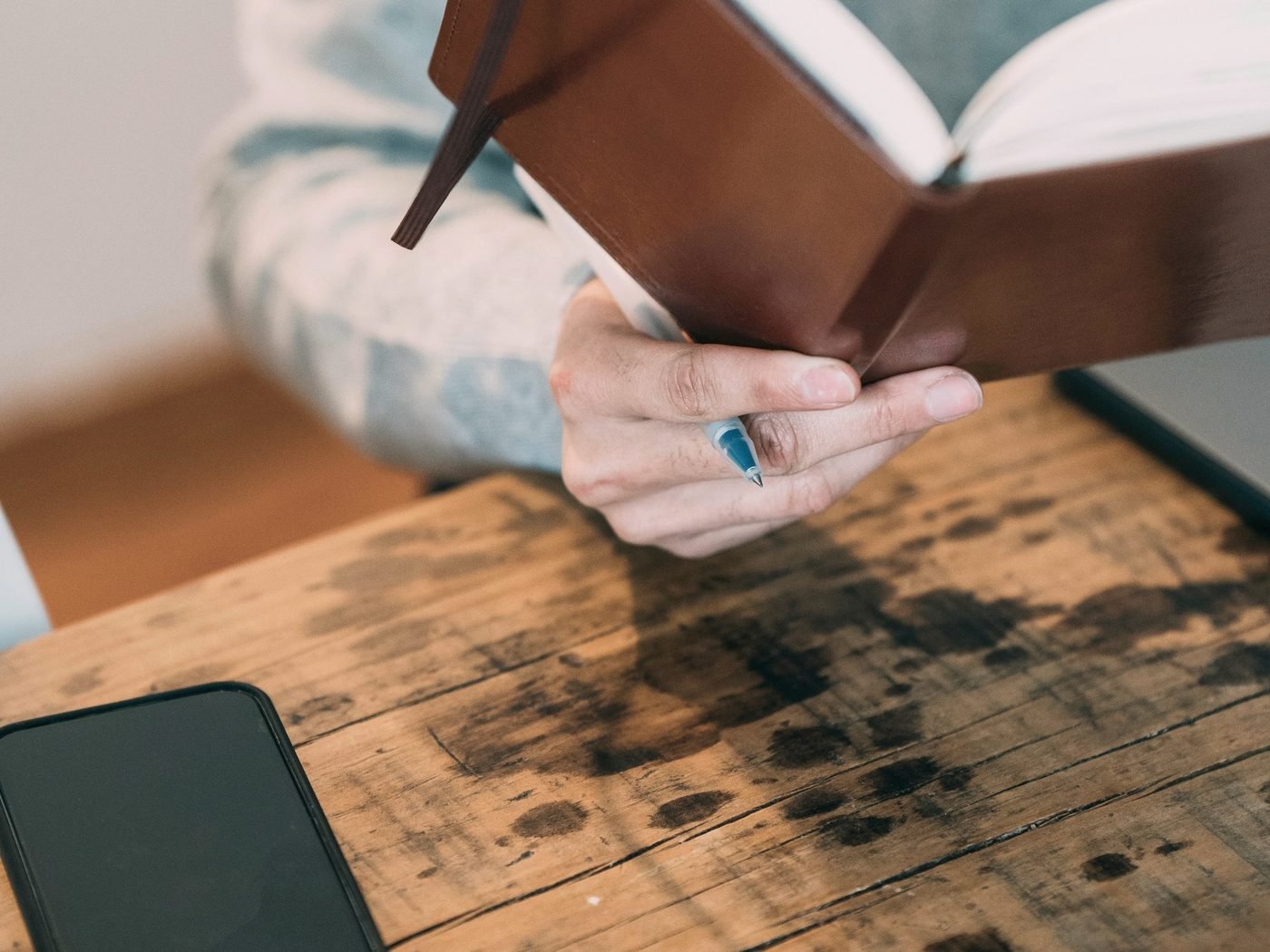 Planner and phone on a wooden desk